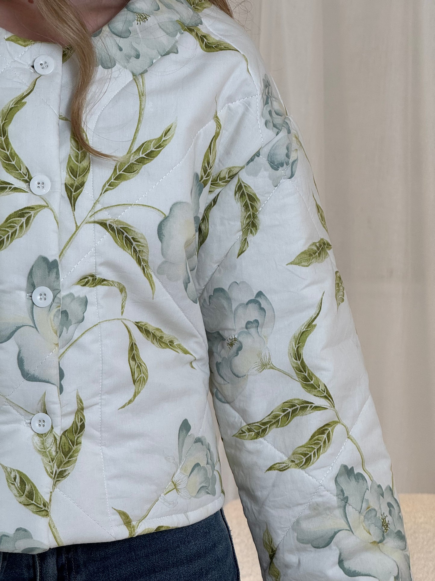 Woman wearing a repurposed floral quilted jacket, sustainable outerwear