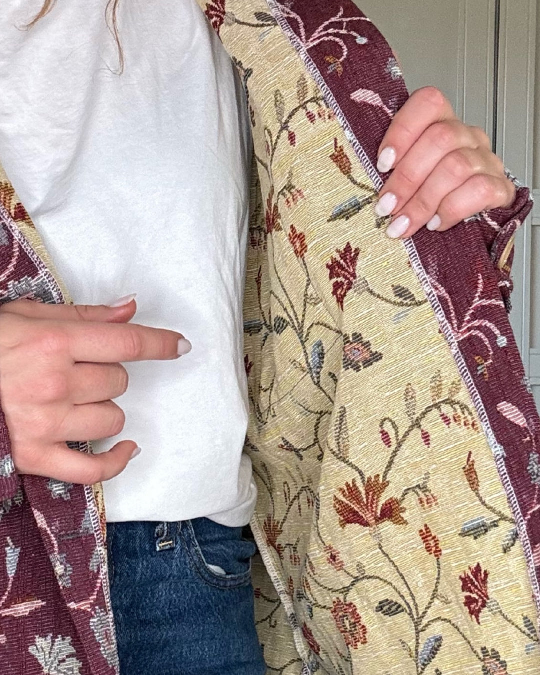 Woman wearing vintage floral jacket made from upcycled curtains, sustainable outerwear