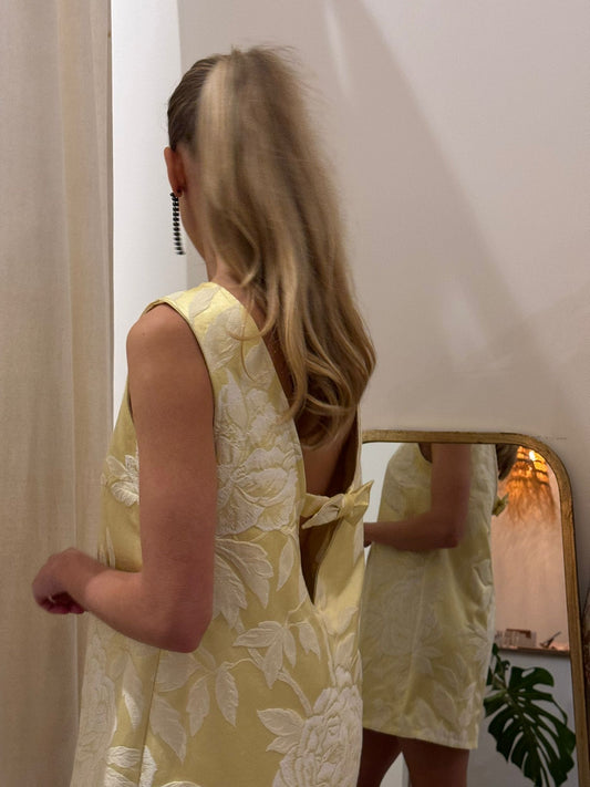 Model wearing gold floral mini dress in Twiggy mod style, upcycled vintage fashion