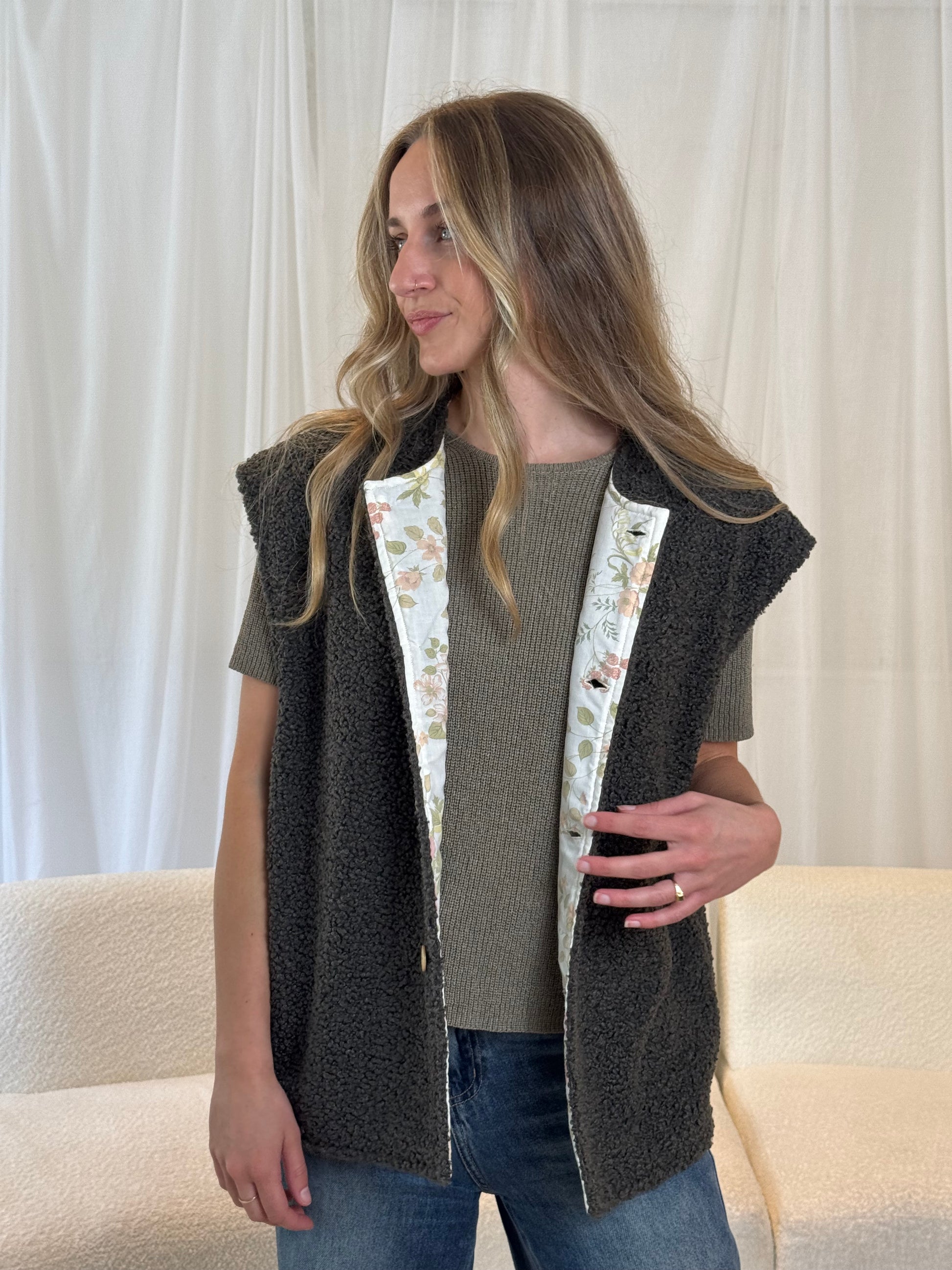 Model in dark grey sustainable gilet vest made from repurposed materials
