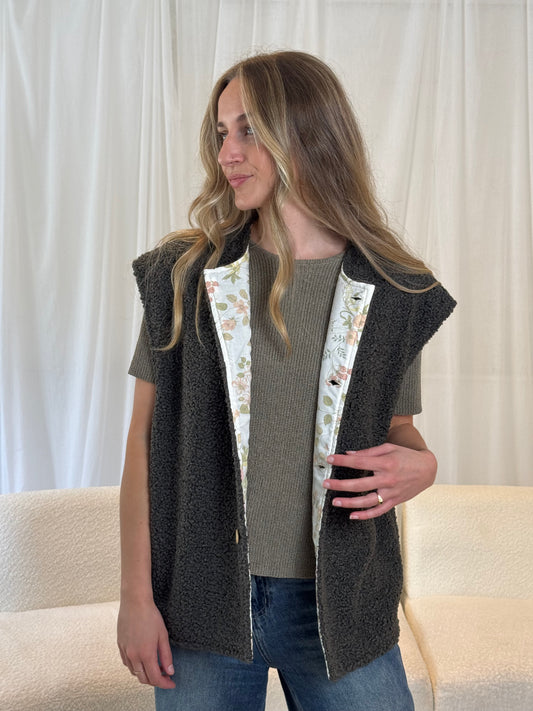 Model in dark grey sustainable gilet vest made from repurposed materials