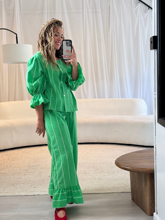 Model wearing green repurposed trousers with frill detail, sustainable fashion